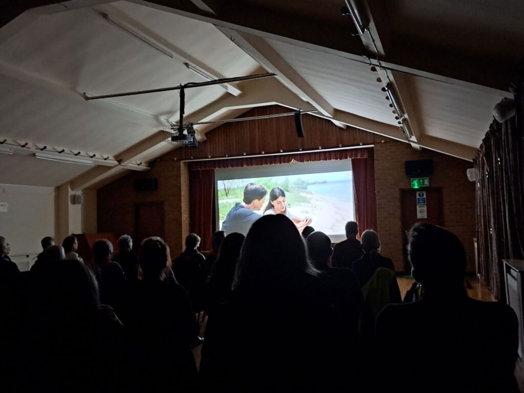 Audience at Bromsgrove Arts watching a film that is being projected on to a large screen