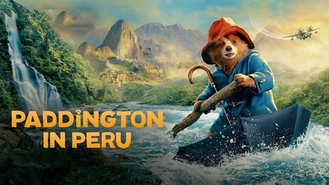 Promotion image of Paddington in an upturned umrella, rafting down a fast flowing river, with mountains in the background