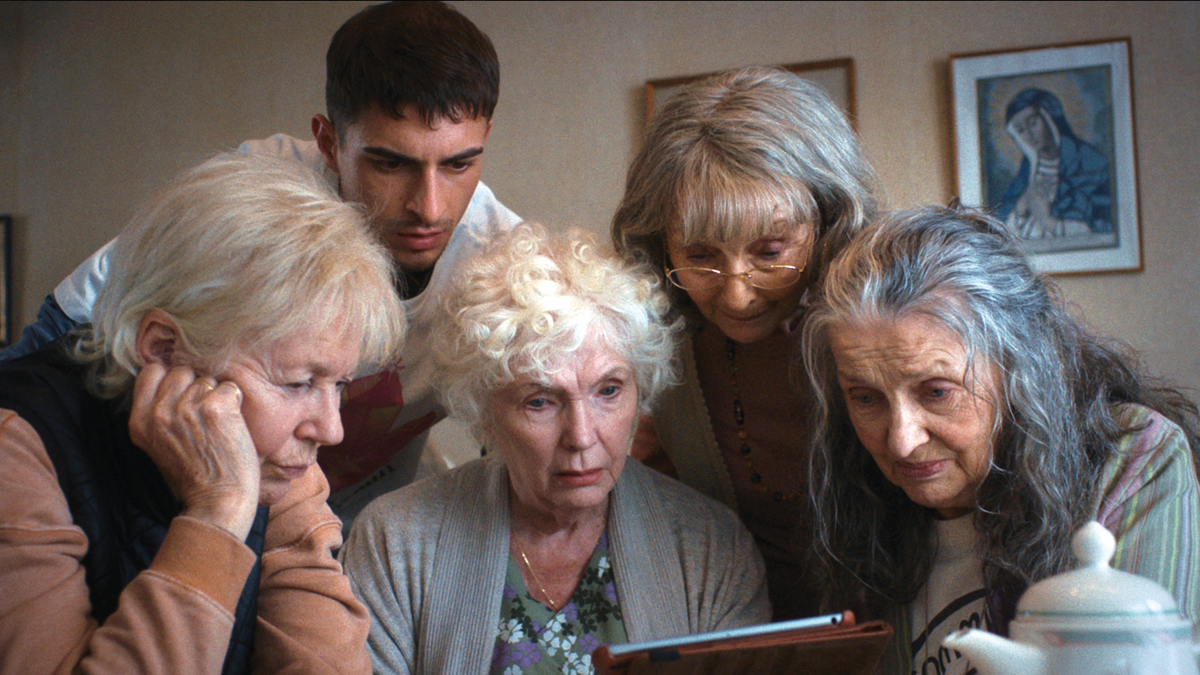 Edward (James McArdle) and the four mothers he is looking after all looking at a tablet