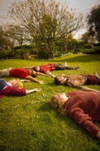 Ponceau - Bromsgrove Arts The band members of Ponceau laid on the grass, arms outstretched and facing the sky.