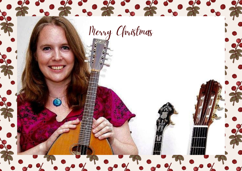Danielle Saxon Reeves smiling towards the camera, wearing a red dress, and three guitars to her side.