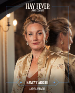 Portrait of Nancy Carroll in a gold satin embroidered jacket; poster reads 'HAY FEVER' by Noël Coward.