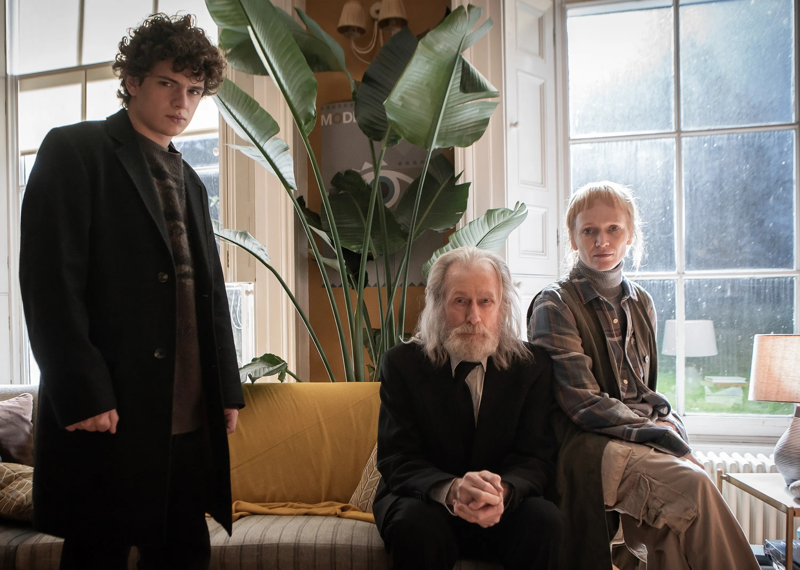 Bill Nighey sat on a yellow settee wearing a dark suit.